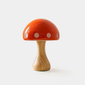 Mushroom table lamp front view with glossy red ceramic dome shade and white dot details on natural wood base