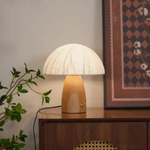 Modern mushroom table lamp in home setting beside wooden cabinet with warm ambient glow