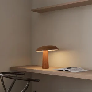 Mushroom shaped table lamp in home study desk setting with minimalist decor and solid wood base