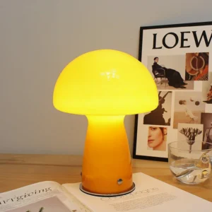 Retro mushroom lamp illuminated on home office desk with magazines and art poster, warm yellow light glow