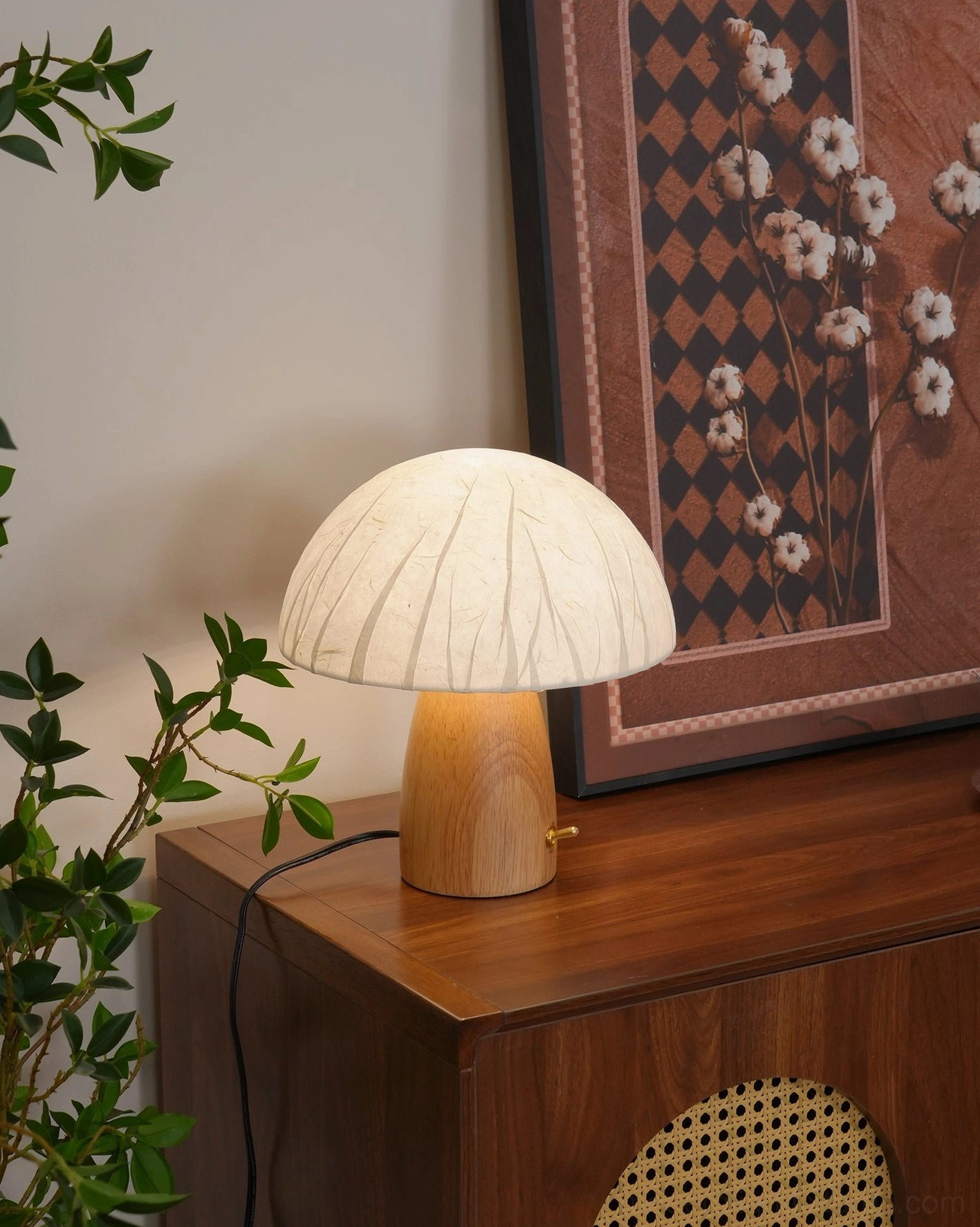 Modern mushroom table lamp illuminated in styled home interior with plant decor