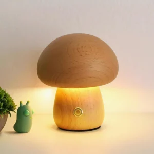 Mushroom table lamp displaying warm LED glow on desktop with natural wood grain visible and decorative green plant accent