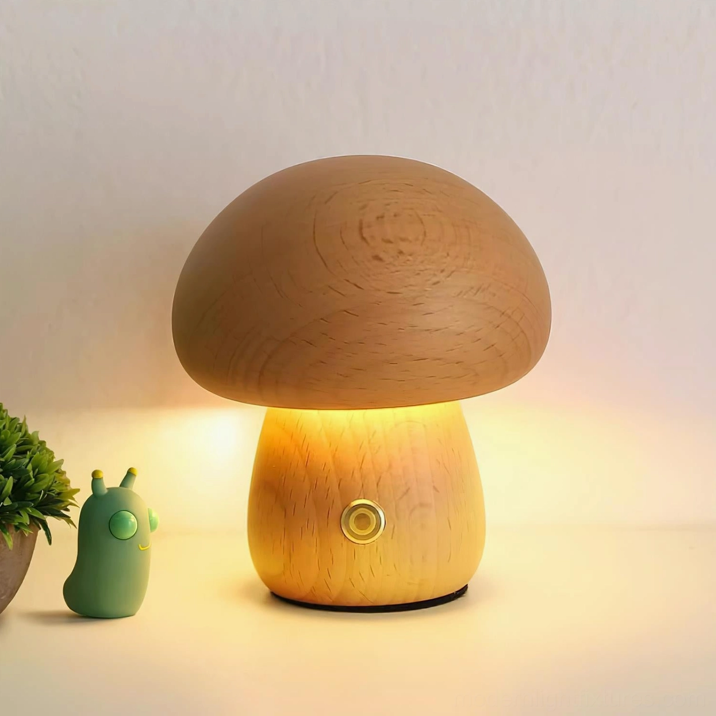 Mushroom table lamp displaying warm LED glow on desktop with natural wood grain visible and decorative green plant accent