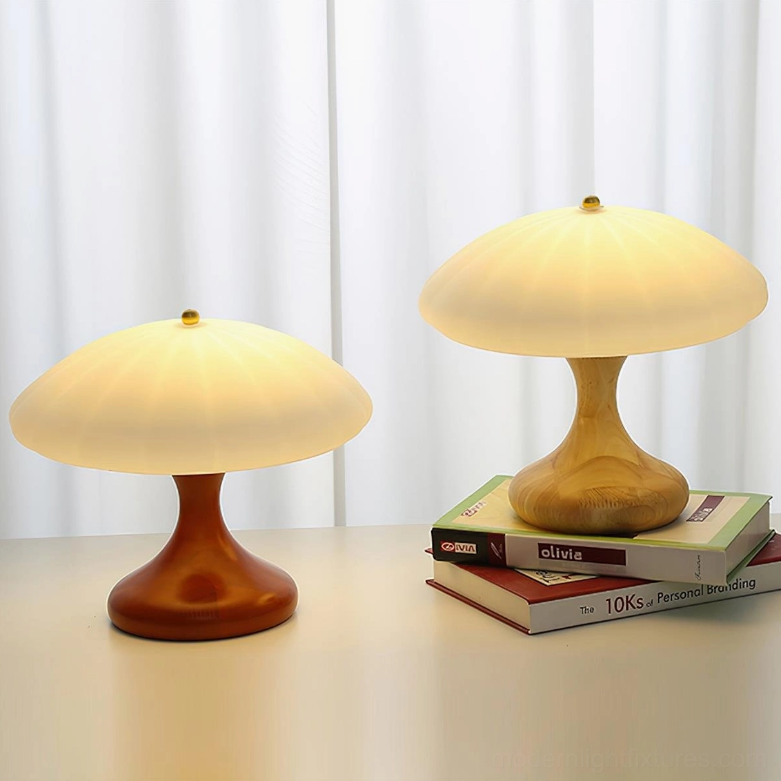 Two mushroom table lamps comparison featuring light and dark wood base variants stacked on books, modern desk display right angle view