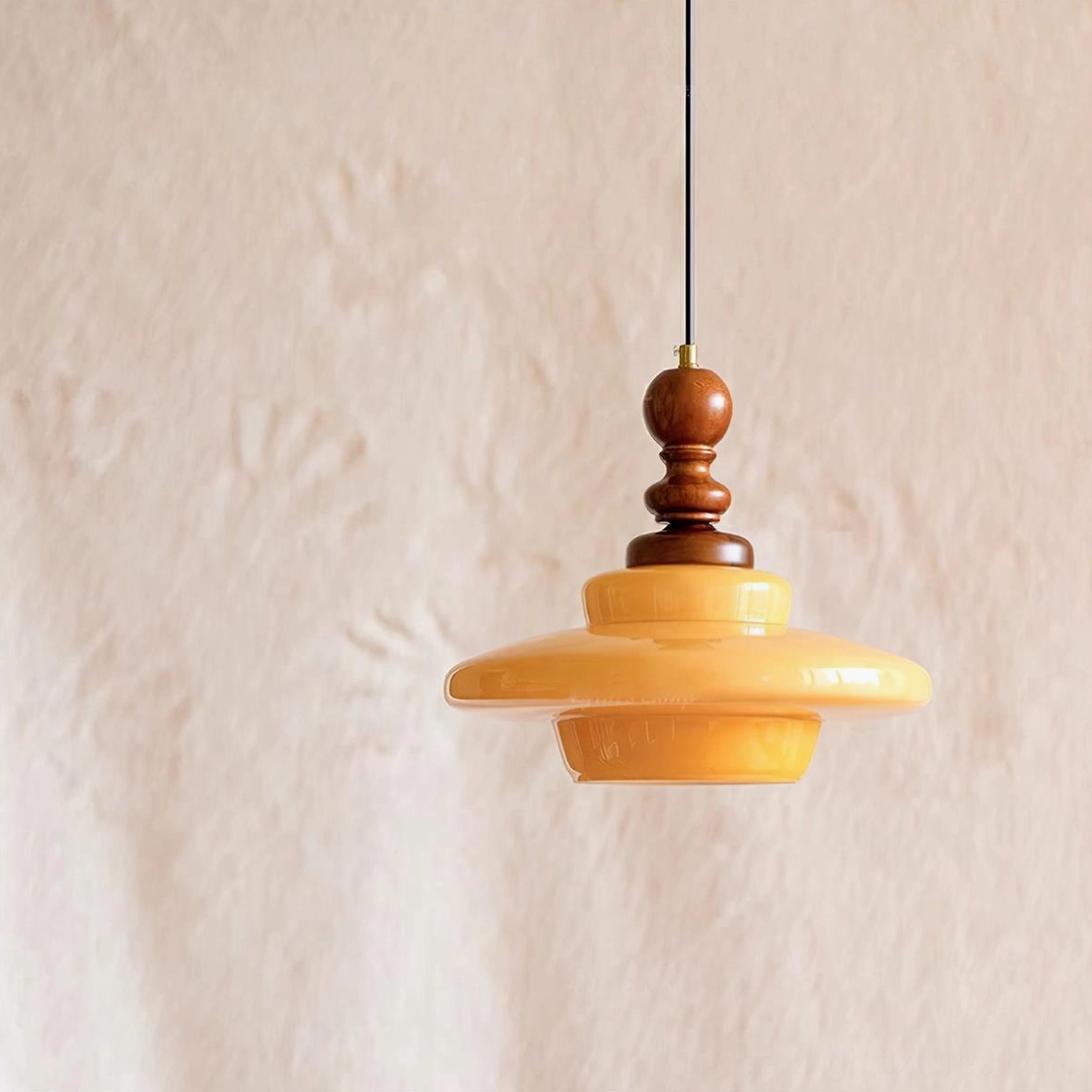 Mid-century modern pendant light with walnut wood and mustard yellow glass, showing product details and warm illumination
