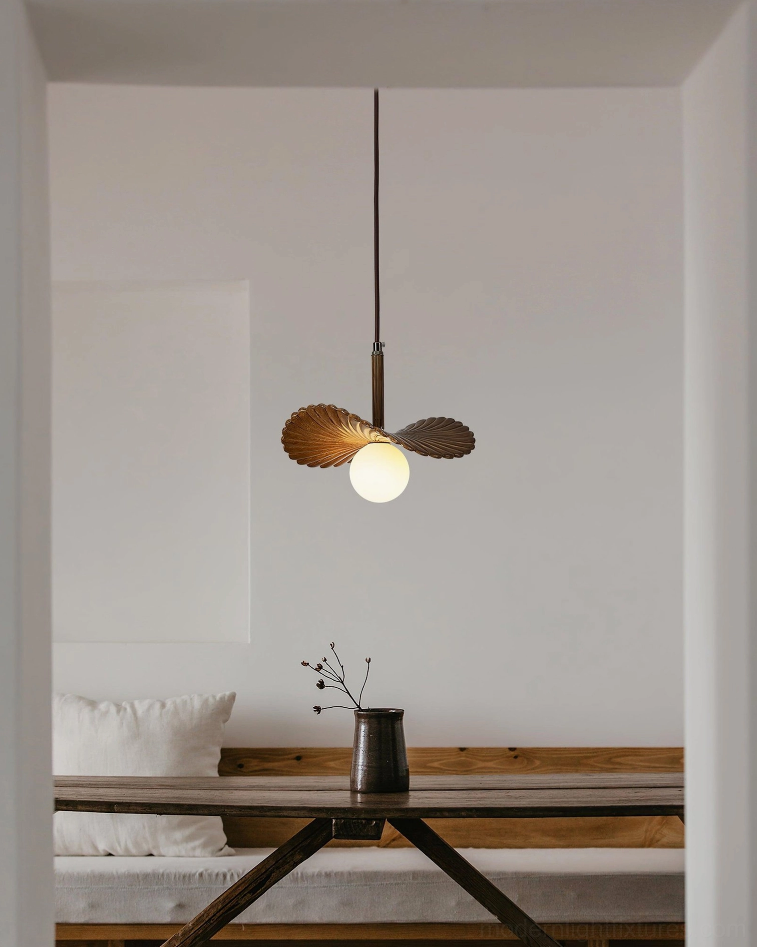 Brown Myrna pendant light suspended in modern dining nook with wooden table, rustic minimalist home decor interior design