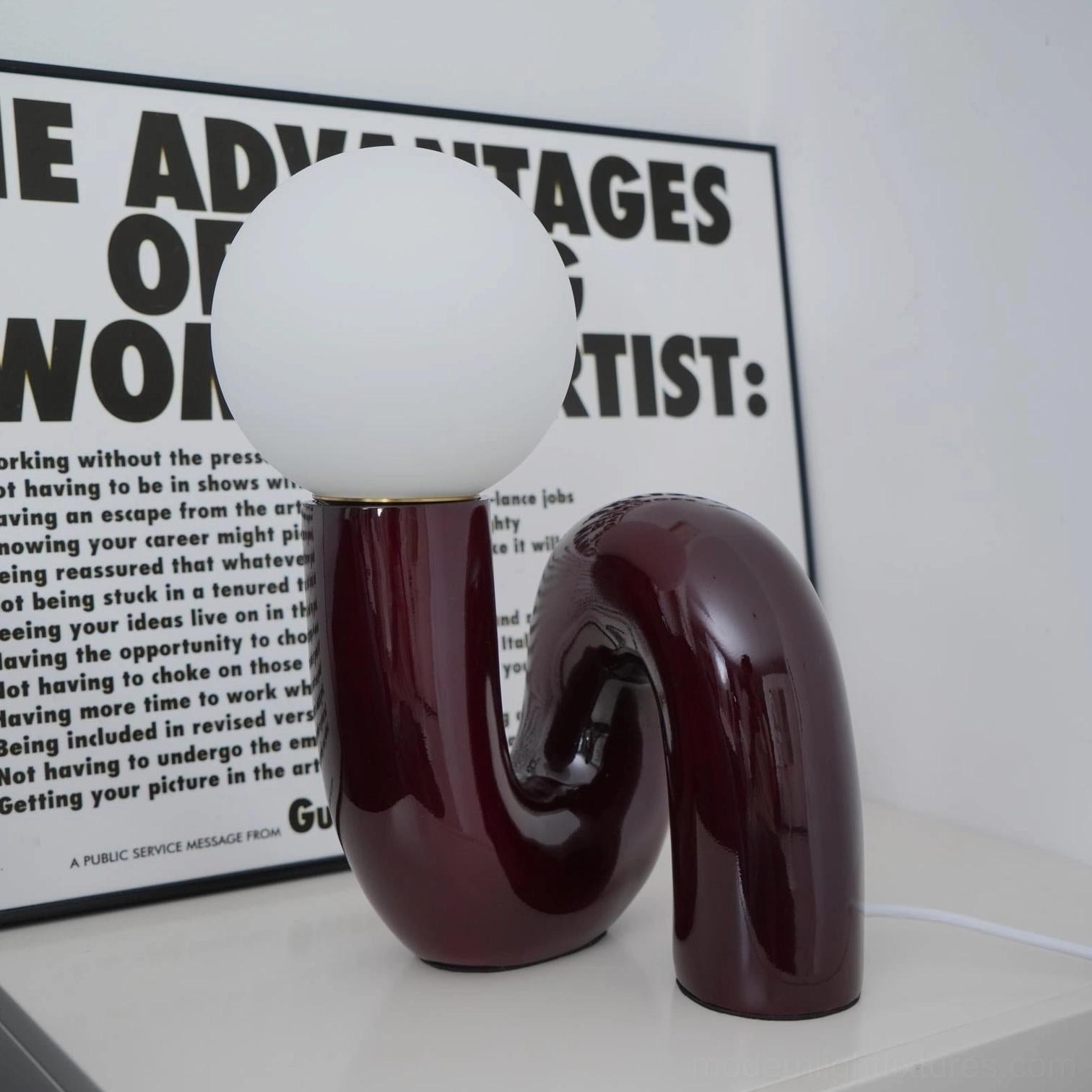 Contemporary N-shape glass table lamp three-quarter view showing sculptural ceramic base form