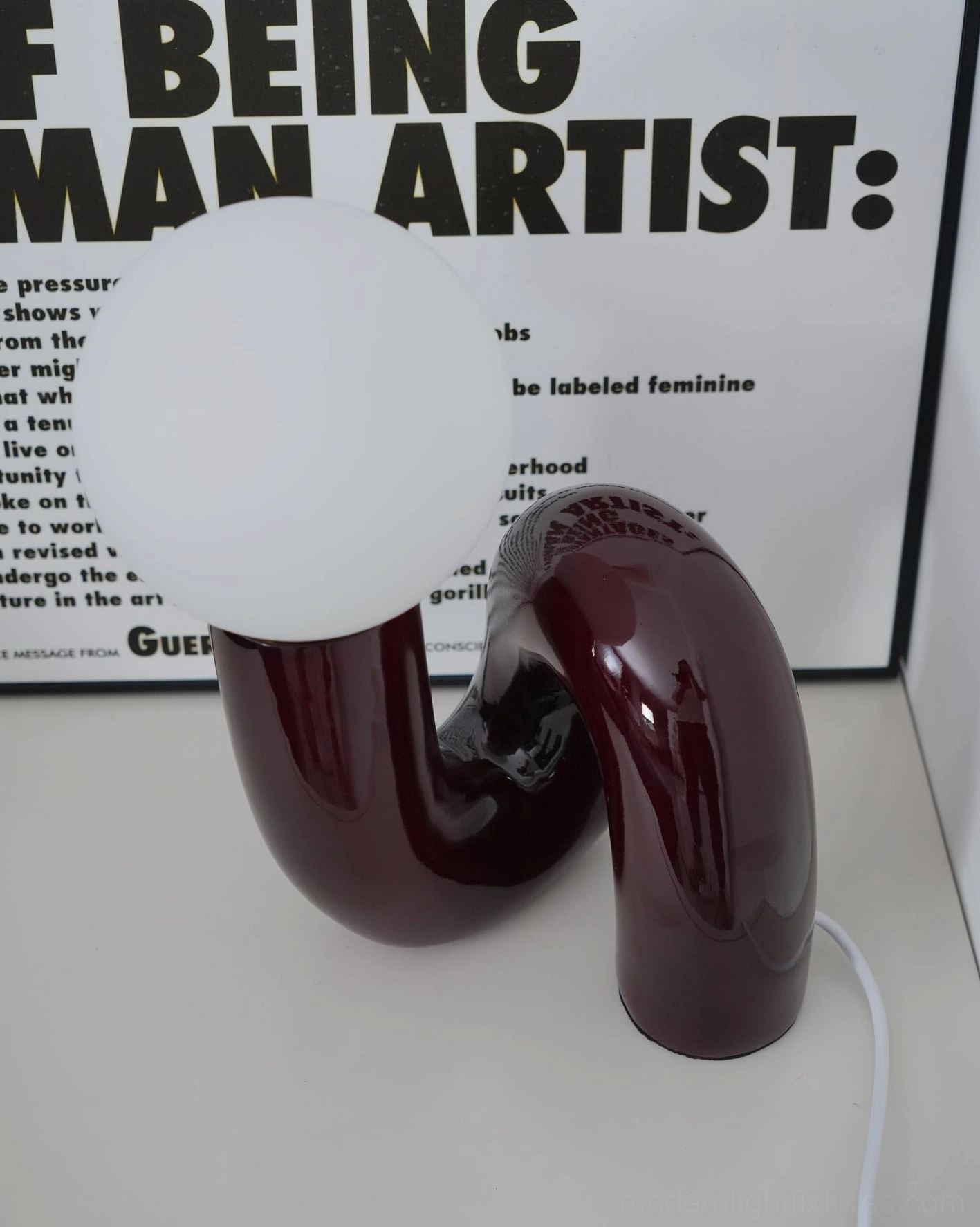 N-shape glass table lamp base detail highlighting smooth curved ceramic surface and form