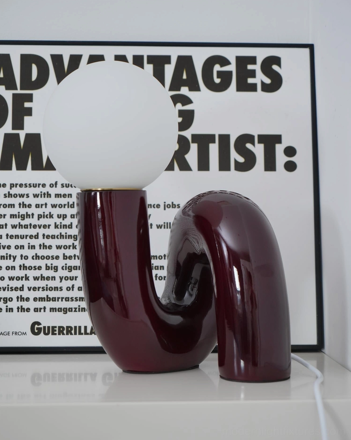 Modern N-shape table lamp showing light diffusion through frosted resin glass shade