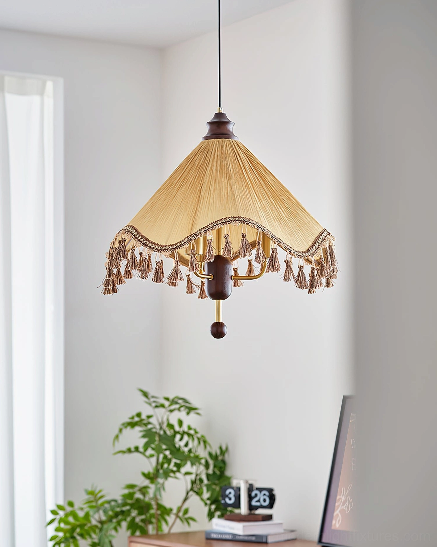 Nadia bohemian vintage pendant lamp hanging in home corner with green plant and table decor, khaki pleated shade with tassel fringe