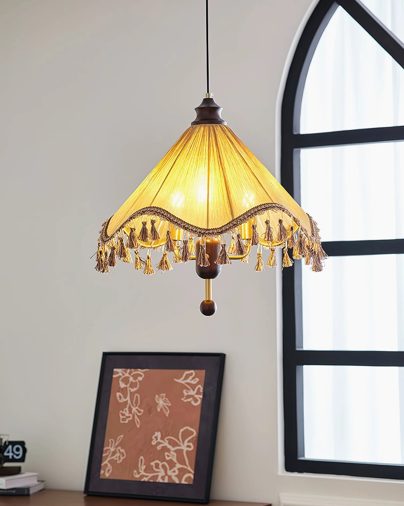 Nadia fabric pendant light illuminated with warm yellow glow, dark wood base hardware shown in arched window interior setting