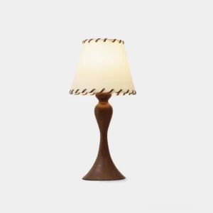 Nala wood table lamp with linen shade and hand-stitched trim on curved wooden pedestal