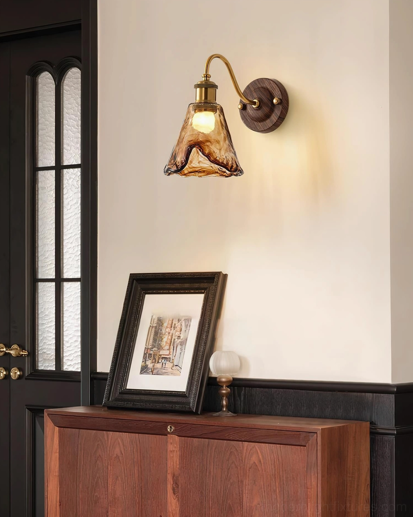 Contemporary wall sconce installed in residential hallway entryway with two-tone painted wall and wooden furniture