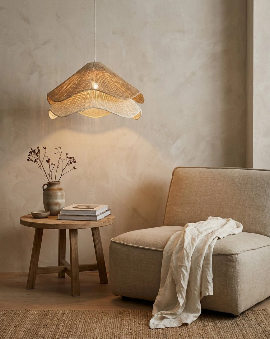 Natural fiber jute-cord petal pendant light in boho living room corner with armchair and side table