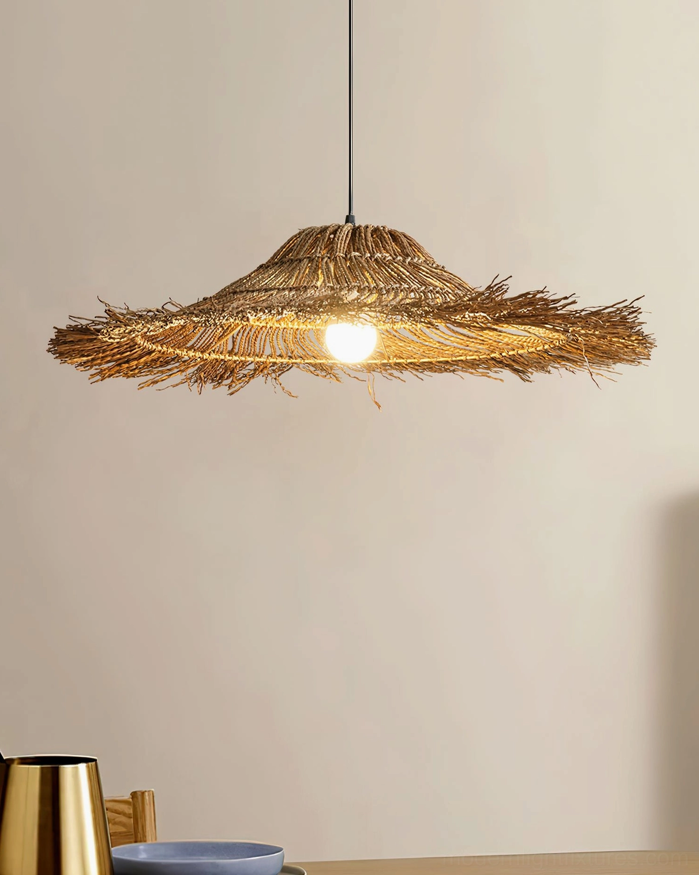 Close-up detail of natural rattan shade with warm bulb, showing handwoven texture and organic frayed edges of boho pendant light