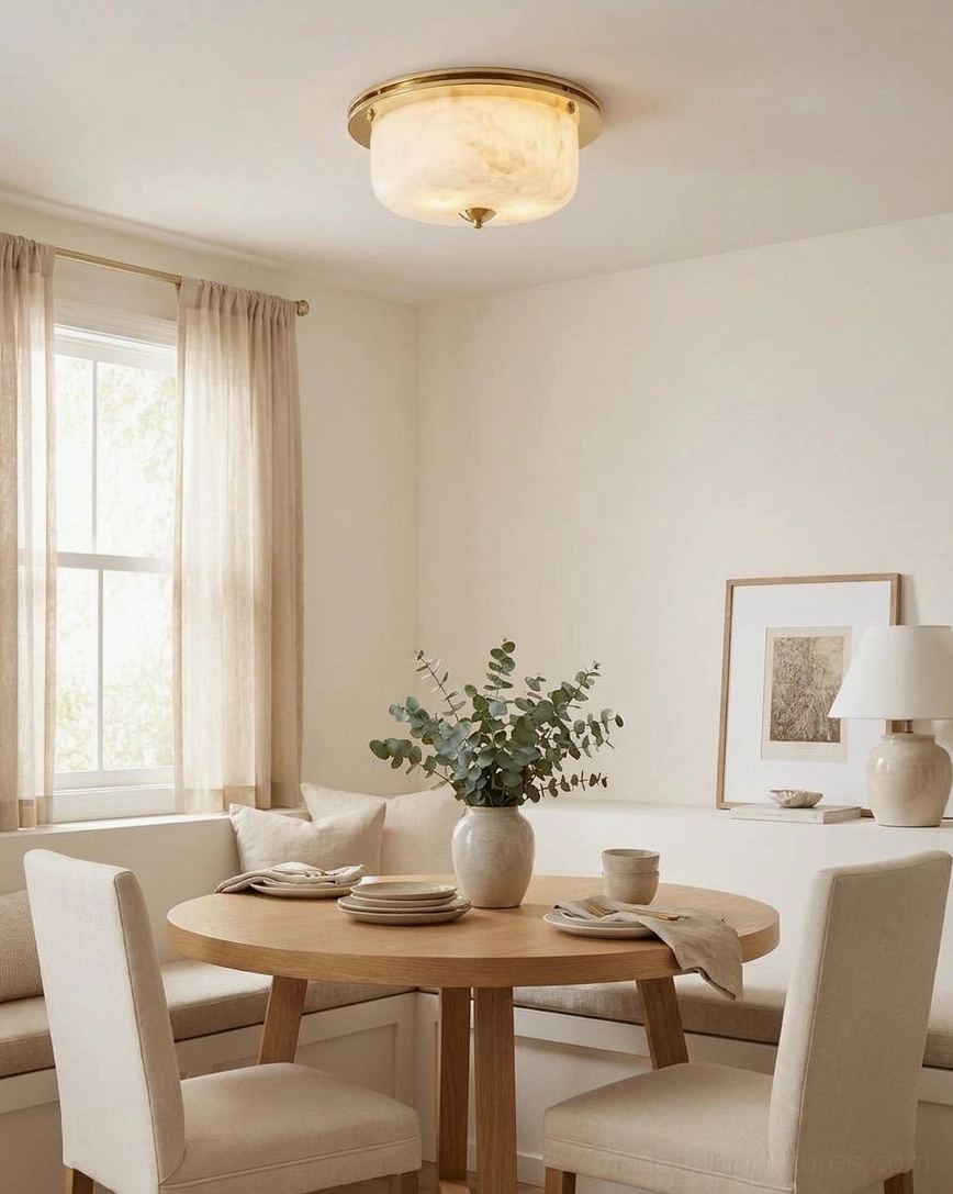 Justice natural alabaster flush mount lighting warm minimalist dining nook with round wooden table and upholstered chairs