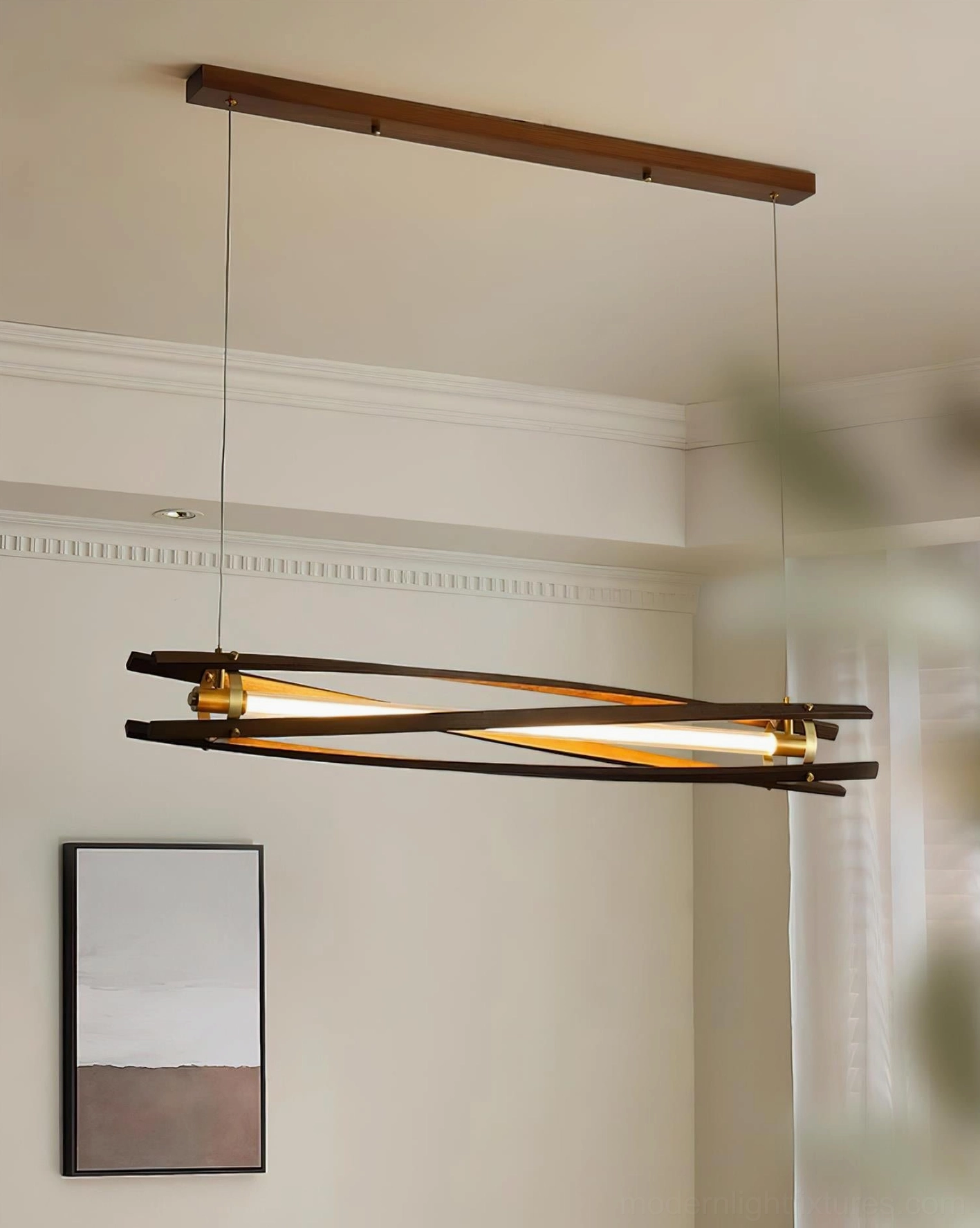 Modern linear wood chandelier with brass accents and natural light wood finish in minimalist home setting