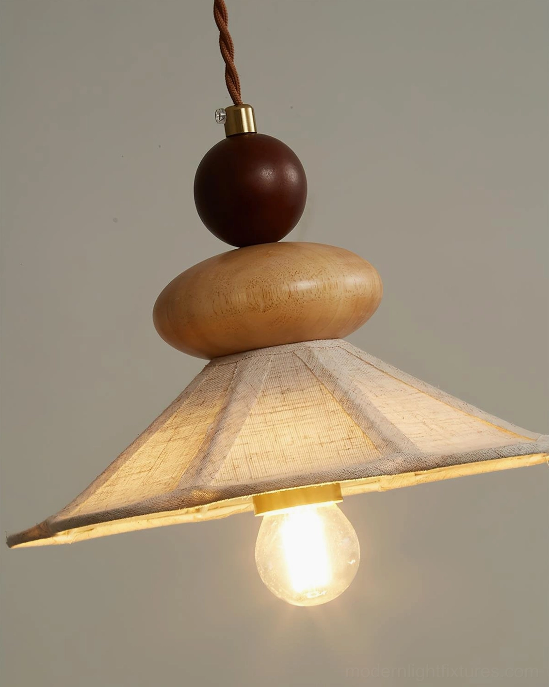 Natural wood pendant lamp with fabric shade creating ambient warm lighting, perfect for dining and bedroom spaces