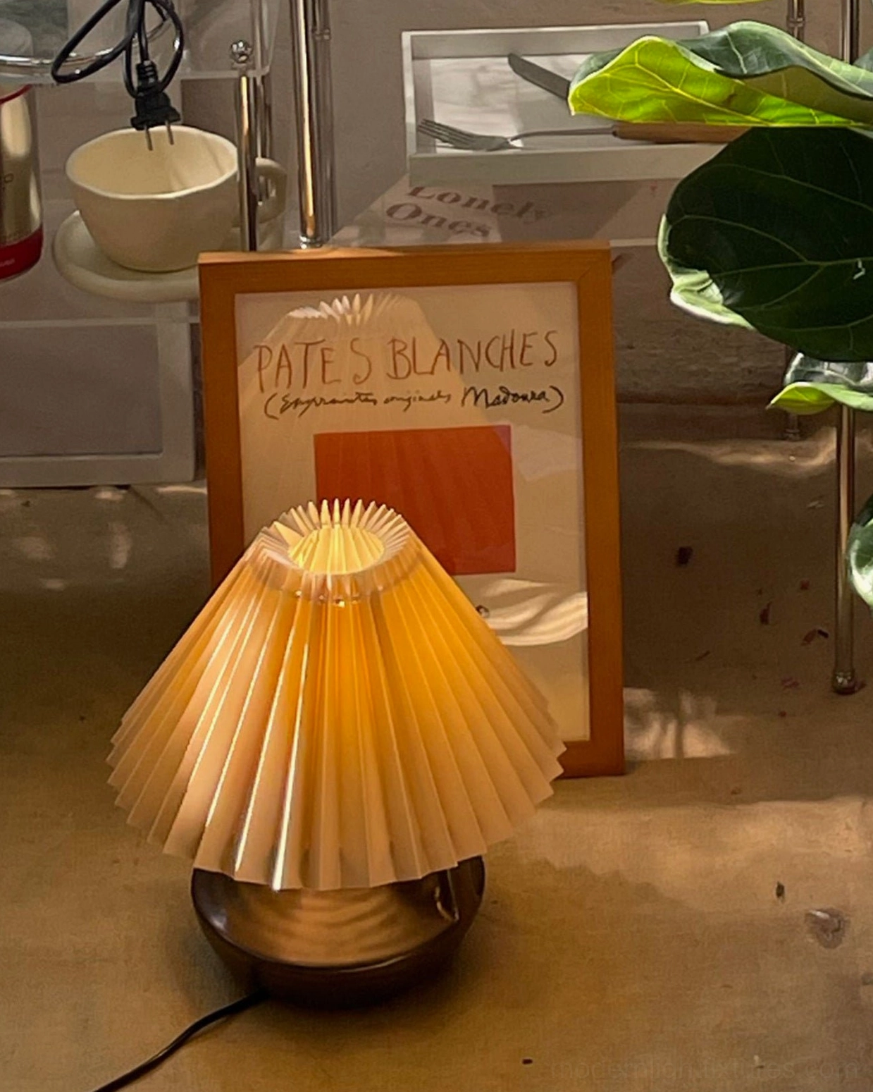 Navia Pleated Table Lamp low angle view on floor display with cream pleated shade and brown ceramic base