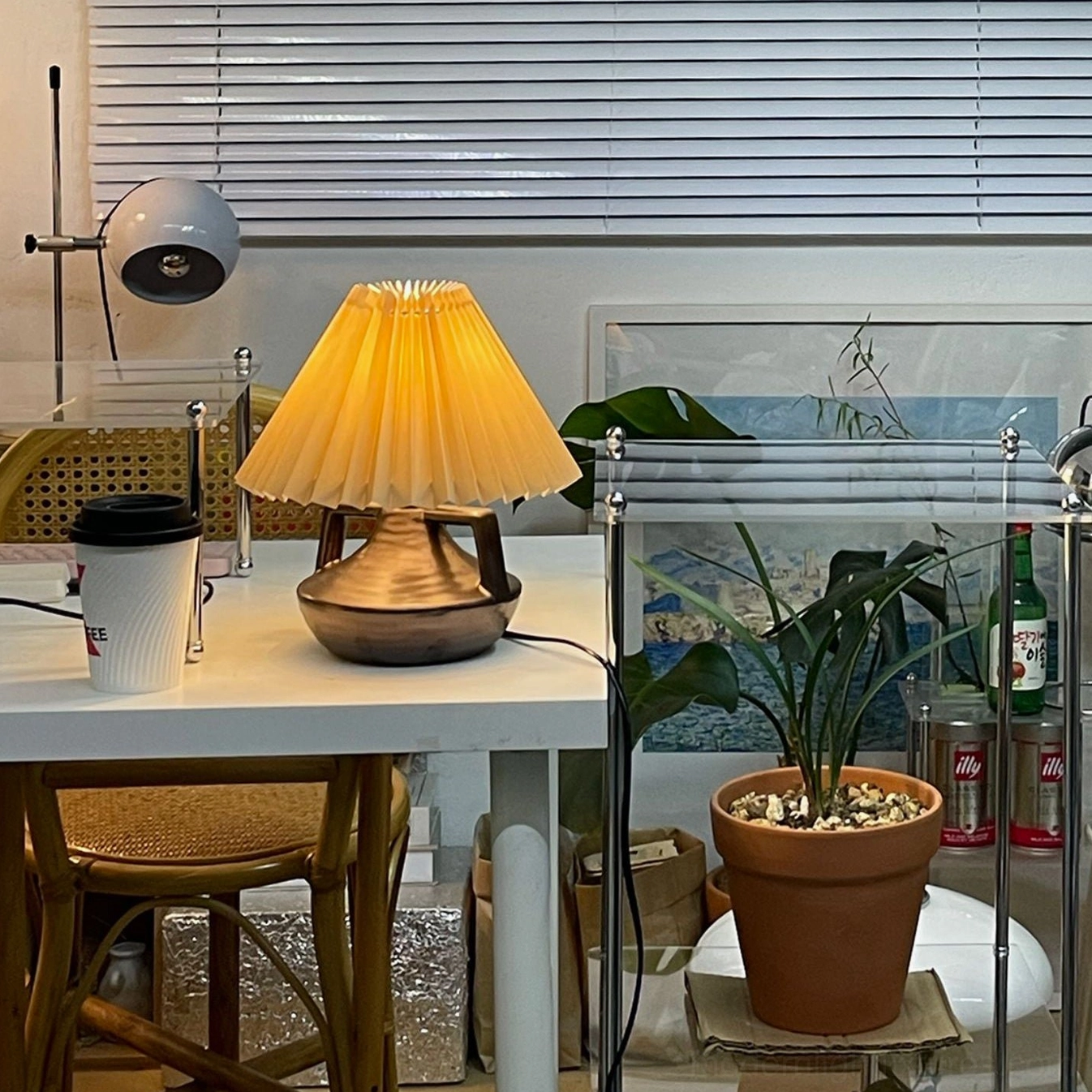 Navia Pleated Table Lamp on home office workspace desk with bronze ceramic base and coffee mug