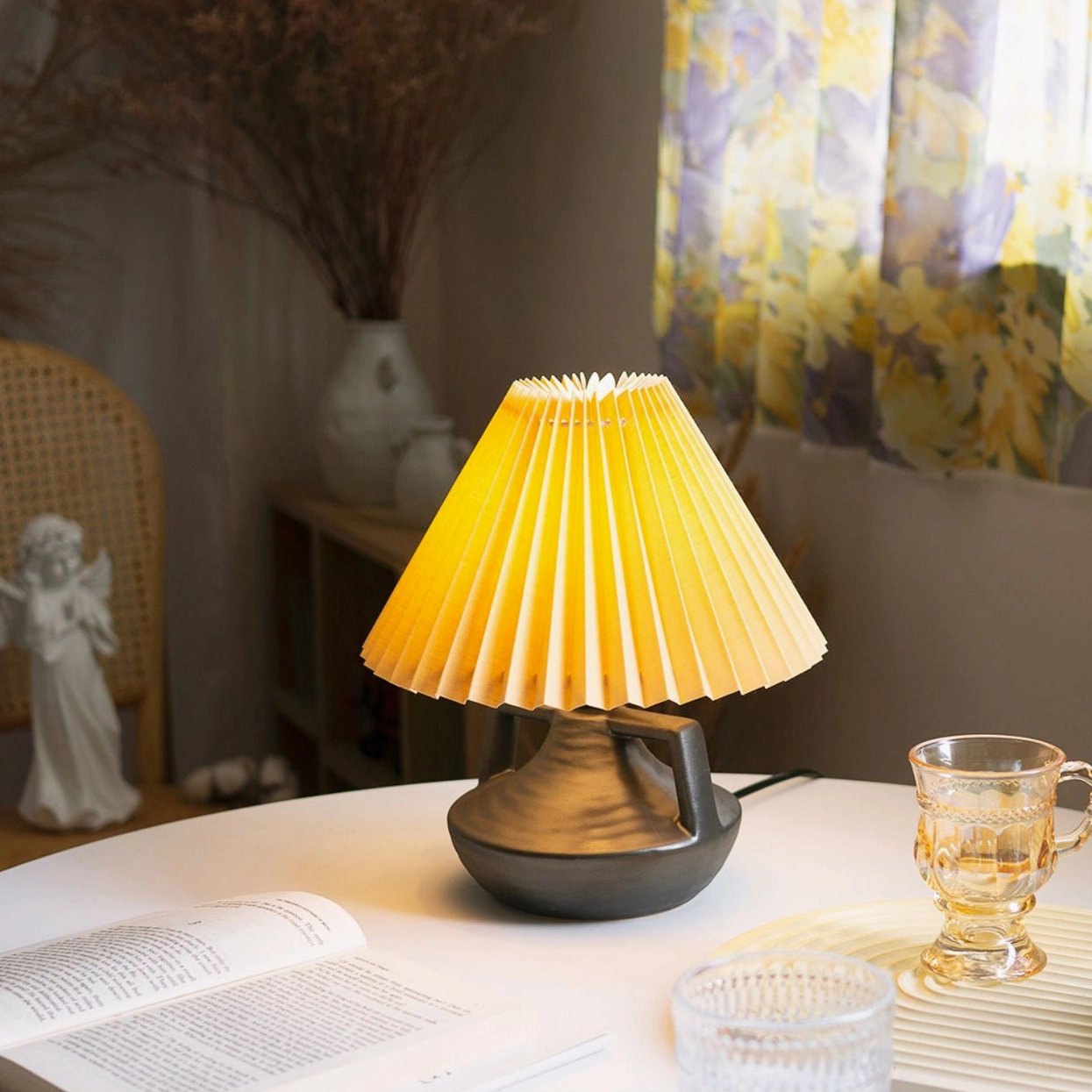 Navia Pleated Table Lamp on dining study table setup with warm glowing pleated shade and books