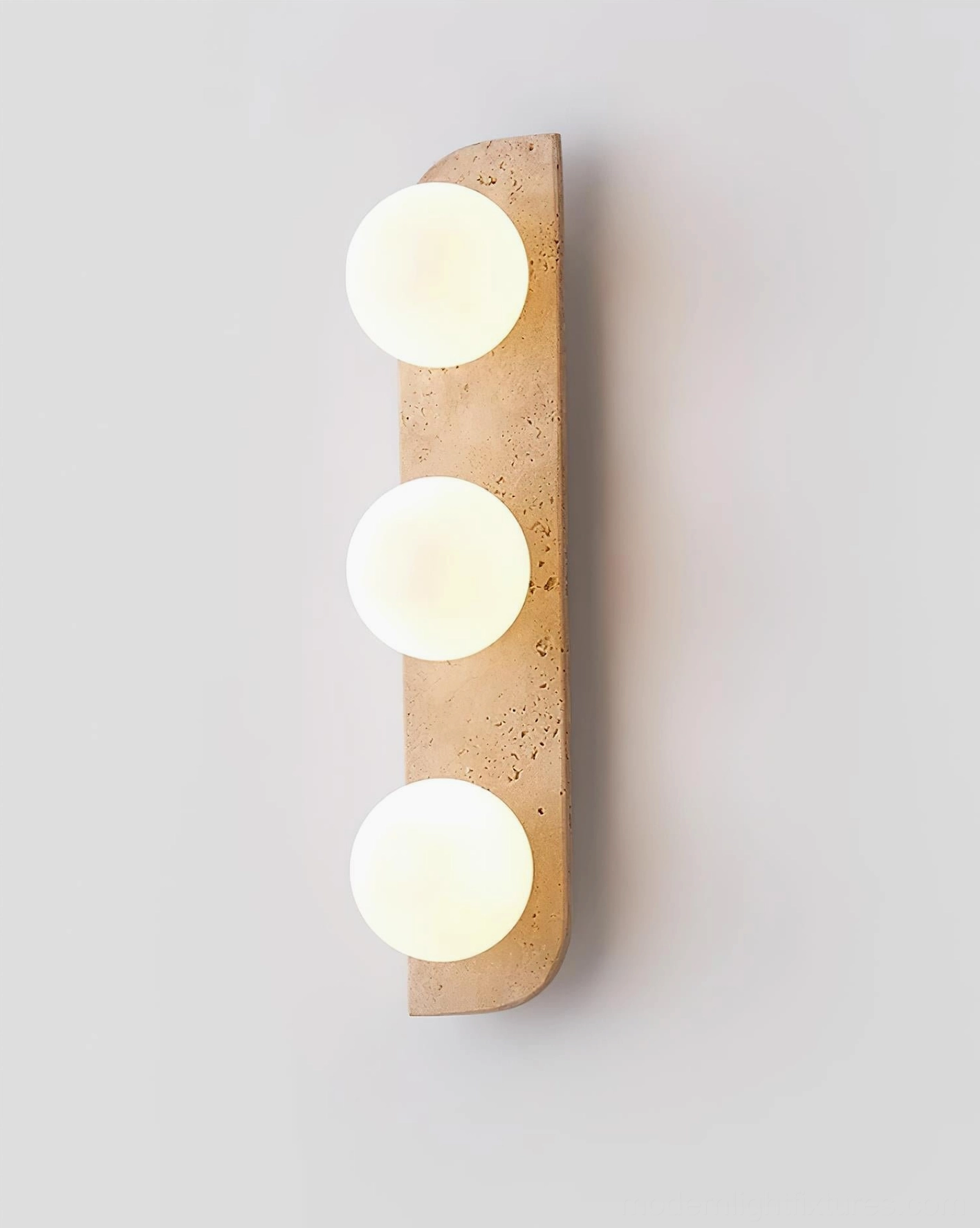 Neptune three-light travertine wall sconce vertical arrangement studio lighting showing warm stone finish
