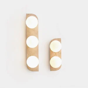 Multiple sizes of Neptune natural travertine wall sconces displayed on white surface showing 1-light, 2-light, and 3-light configurations