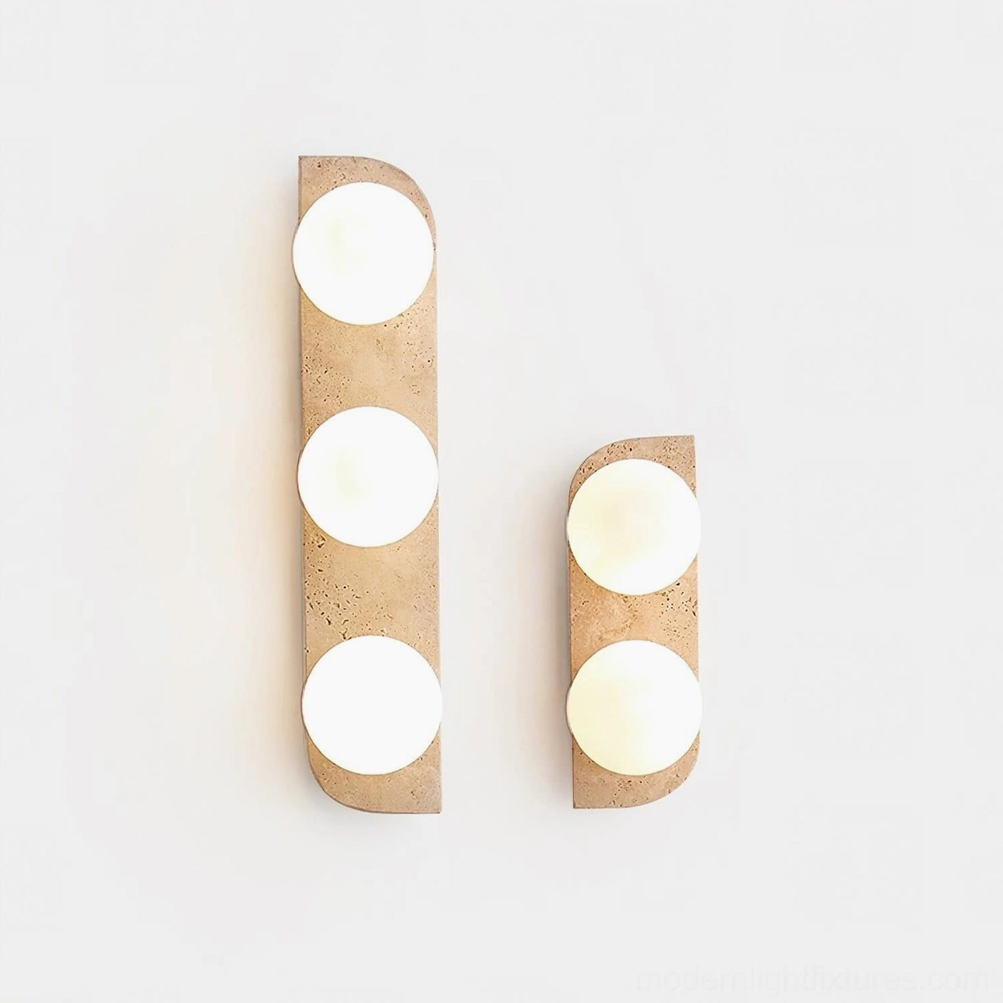 Multiple sizes of Neptune natural travertine wall sconces displayed on white surface showing 1-light, 2-light, and 3-light configurations