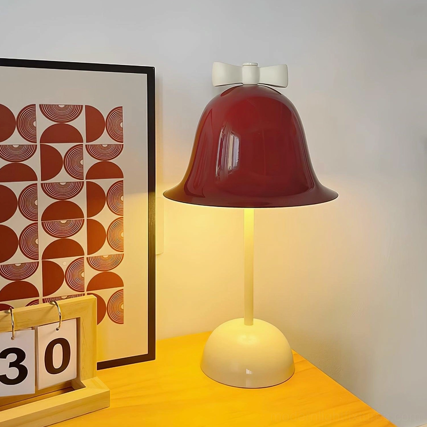 Bow-knot table lamp on yellow side table with geometric art frame and calendar in contemporary interior