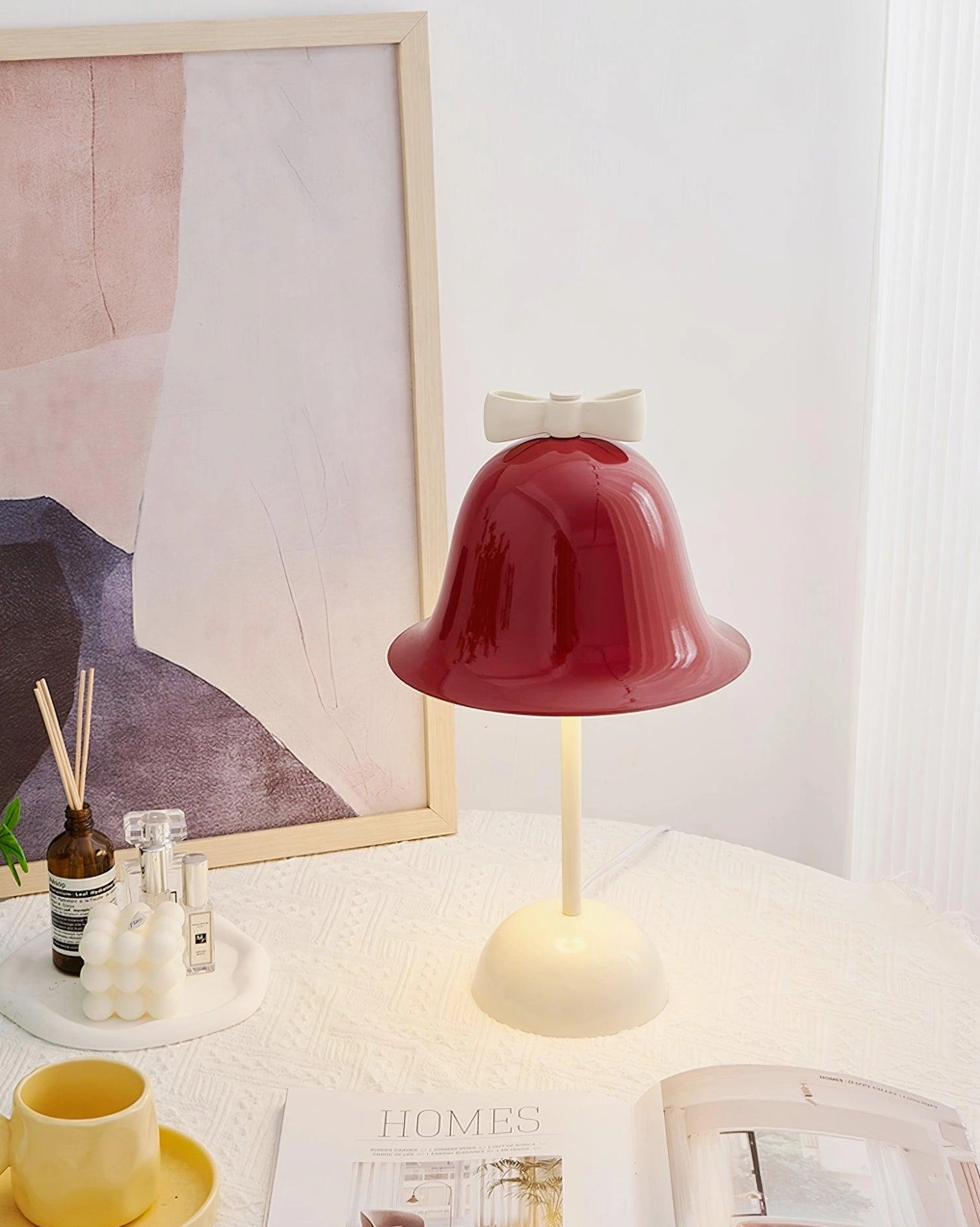 Elegant bow-knot table lamp on bedroom nightstand with framed artwork in modern bedroom setting