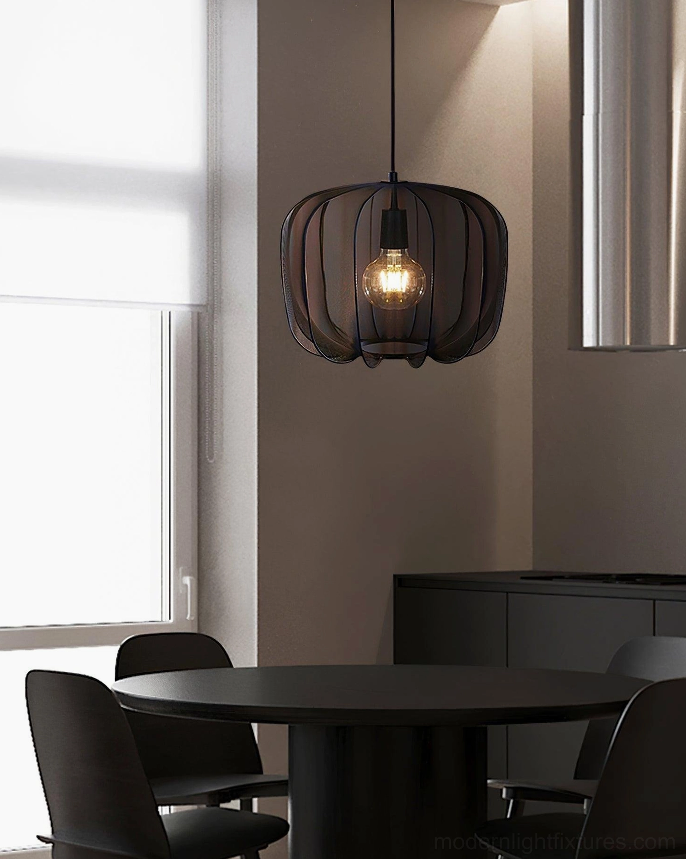 Black Nevola pendant light with ribbed shade in dining area, modern dark interior design setup