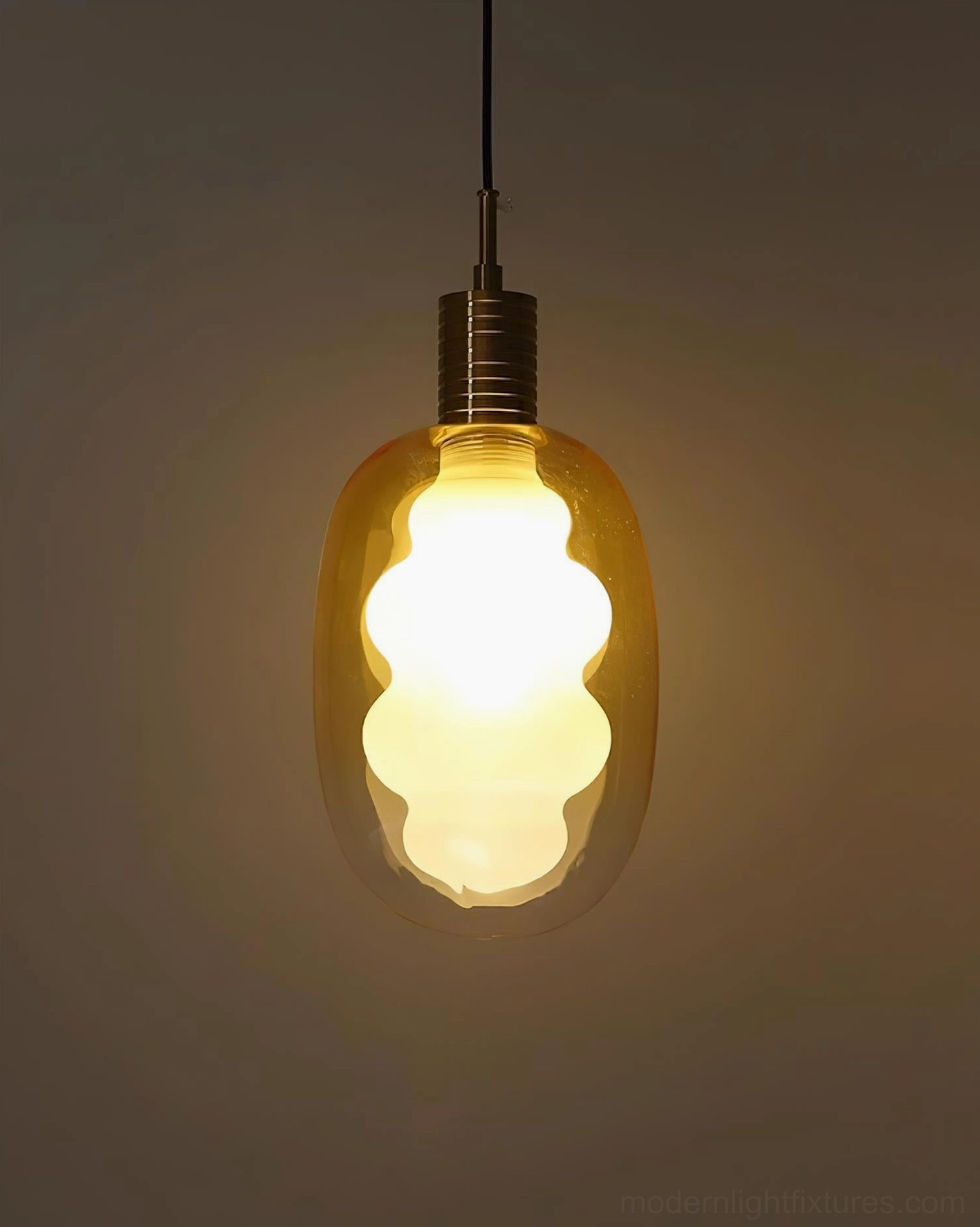 Amber gradient handblown glass pendant light with brass metal cap, warm-toned ambiance, cozy room lighting atmosphere