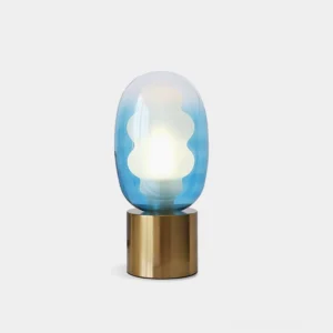 Nimbus table lamp with blue gradient handblown glass shade and brass metal base, illuminated against white studio background