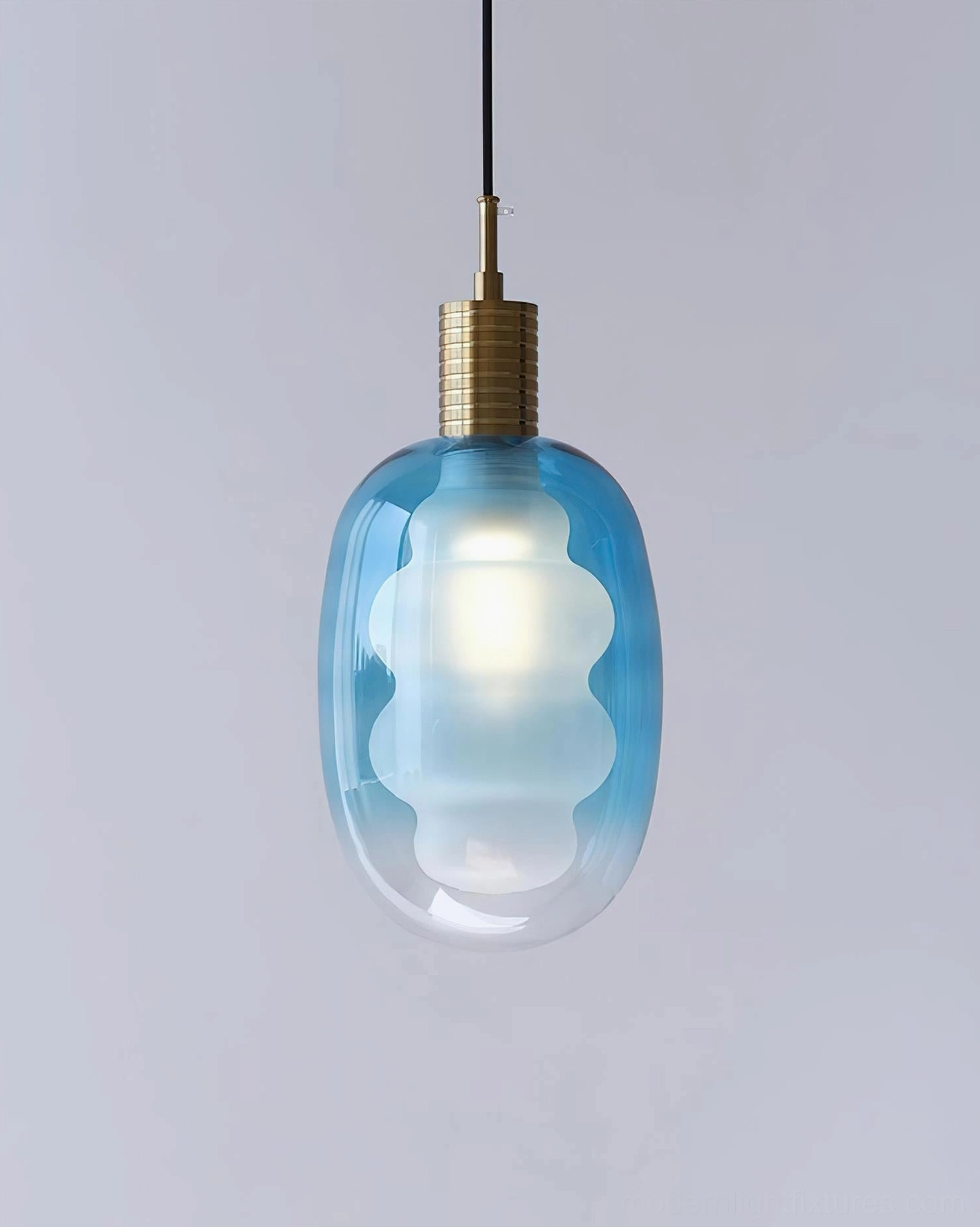 Handblown Nimbus glass pendant light with brass fitting and blue gradient shade, overhead studio photography, contemporary design