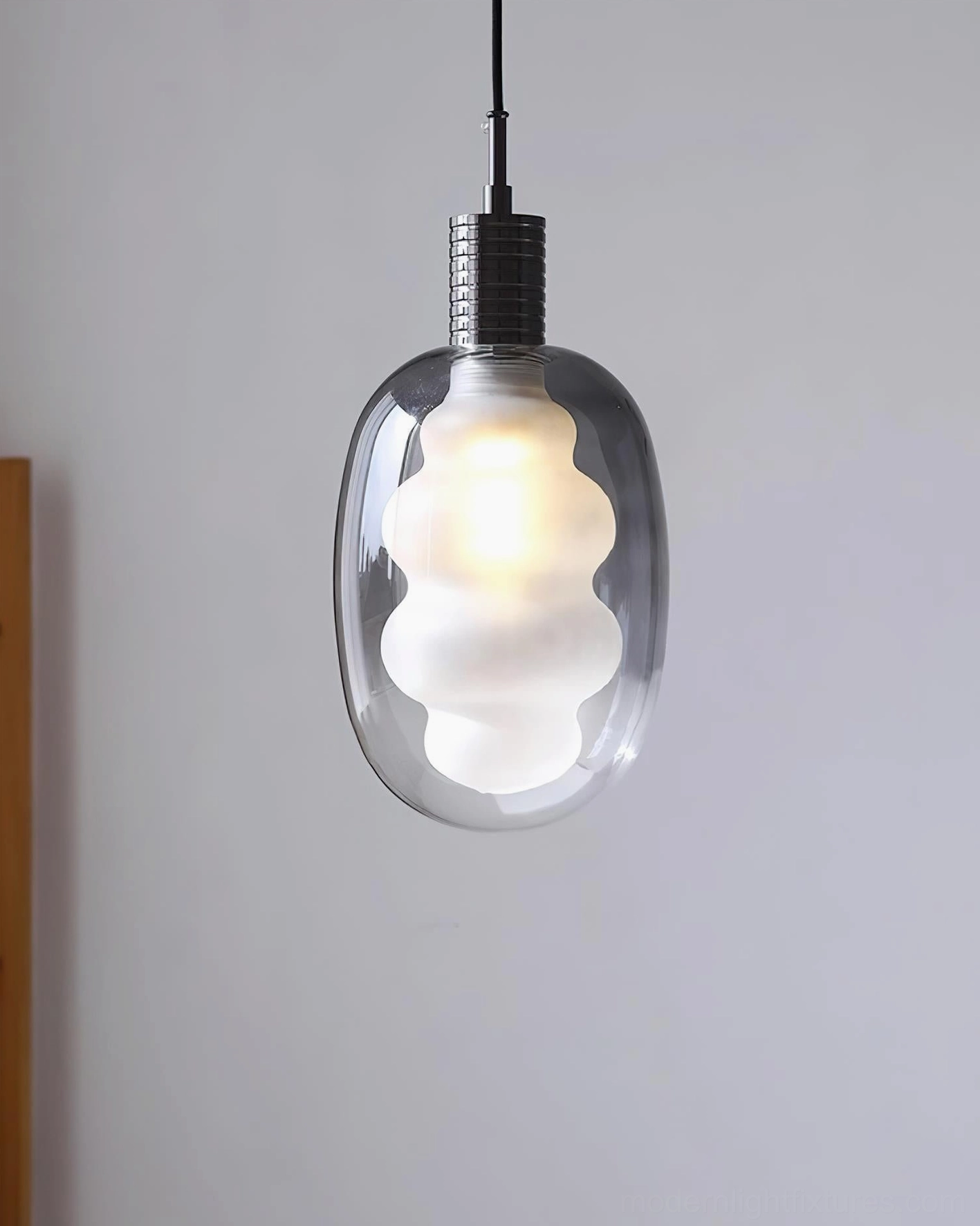 Cloud-shaped modern pendant light with smoky gray glass and black metal fitting, angled view in minimalist interior setting