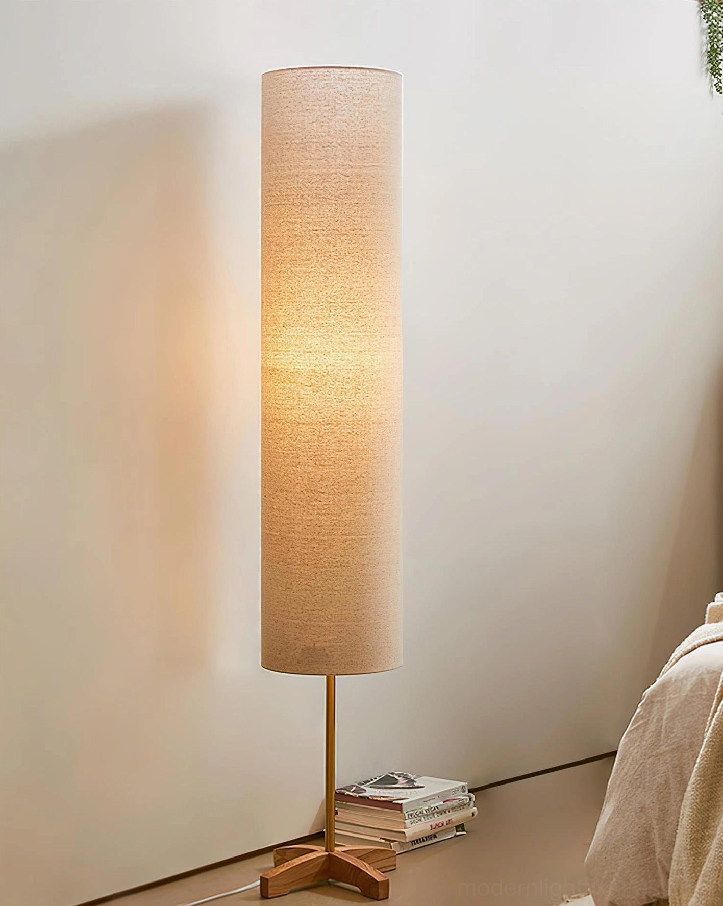 Nomi floor lamp bedside lighting with stacked books creating warm relaxation ambiance in bedroom