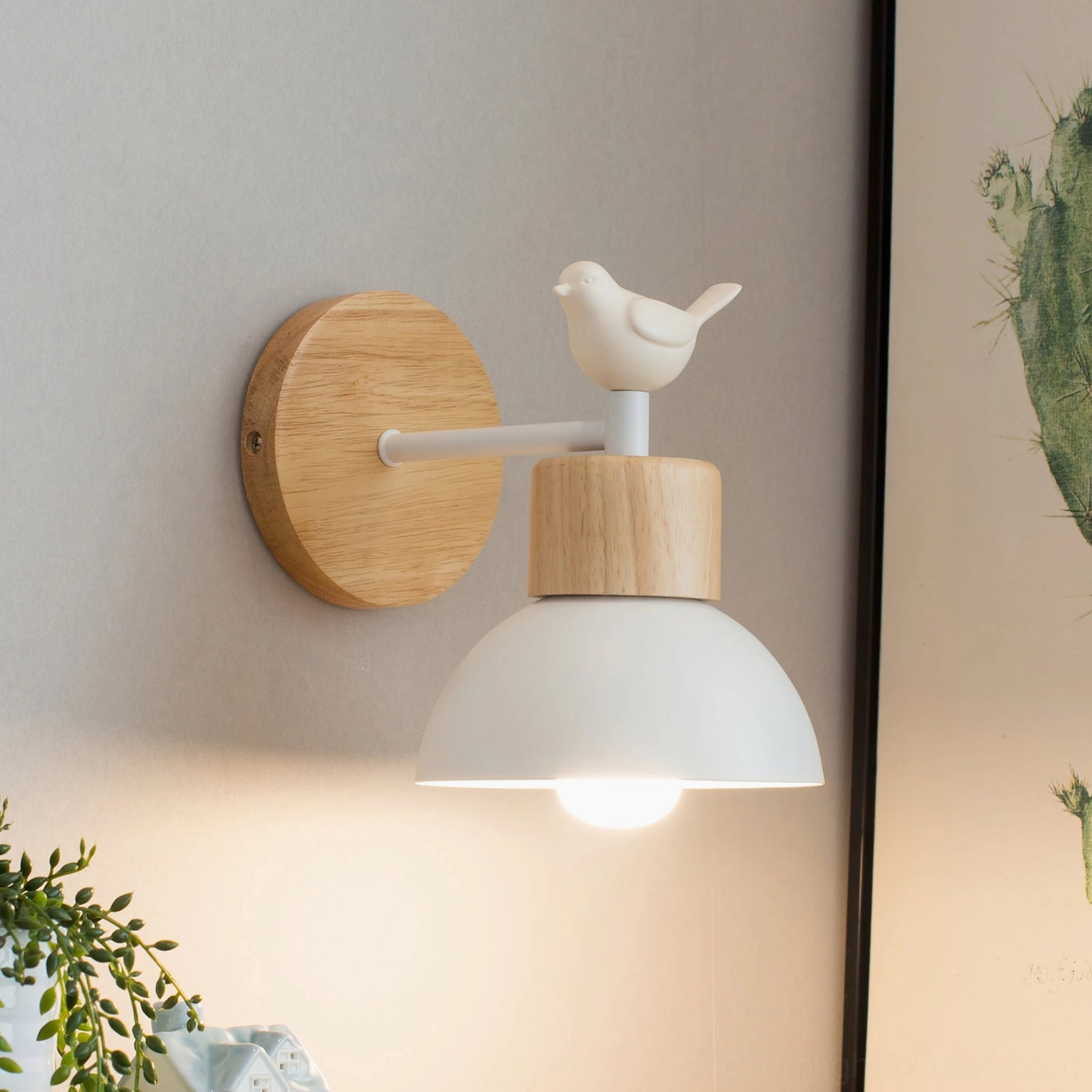 Nordic bird wall sconce mounted on home wall with cactus art and natural light - Scandinavian lighting