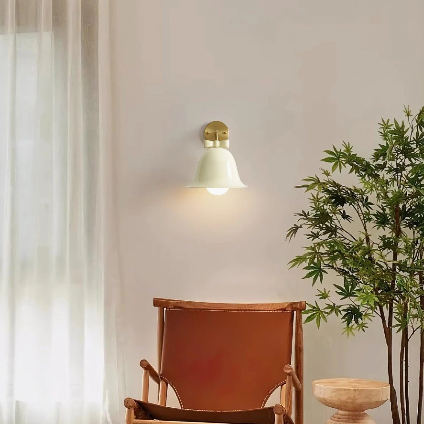 Cream white ceramic bell wall lamp with brass mount installed in cozy Nordic living rest corner