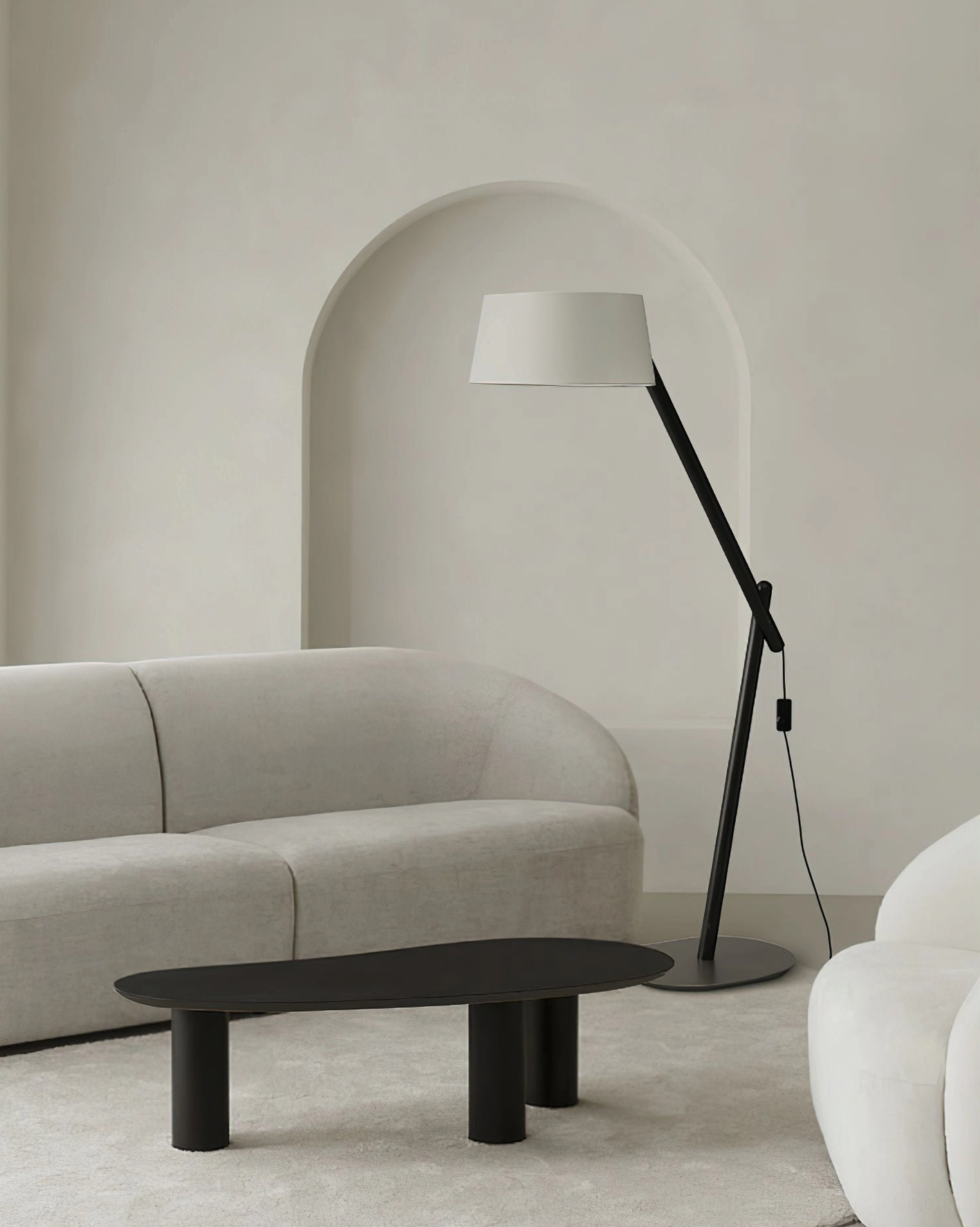 Minimalist arc floor lamp with white fabric shade in Nordic cream living room with curved sofa