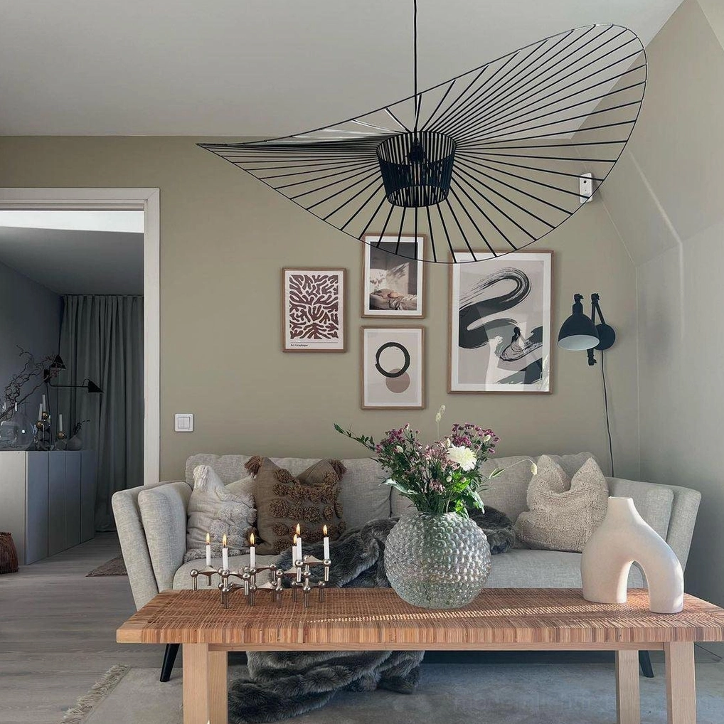Black woven fiber glass pendant lamp installed above wooden coffee table in Nordic style living room