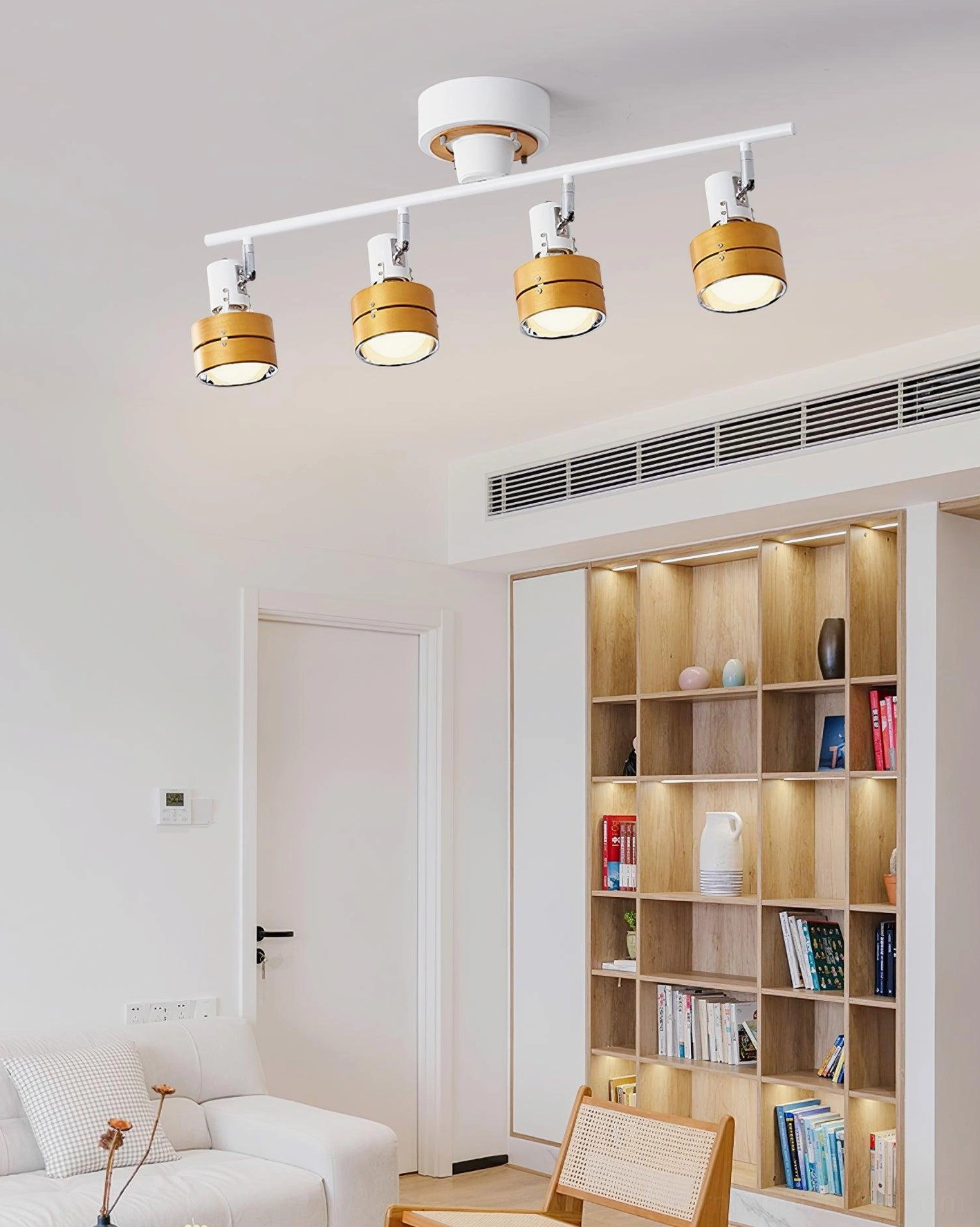 Minimalist white track lighting fixture in modern Nordic-style living room with bookshelf display
