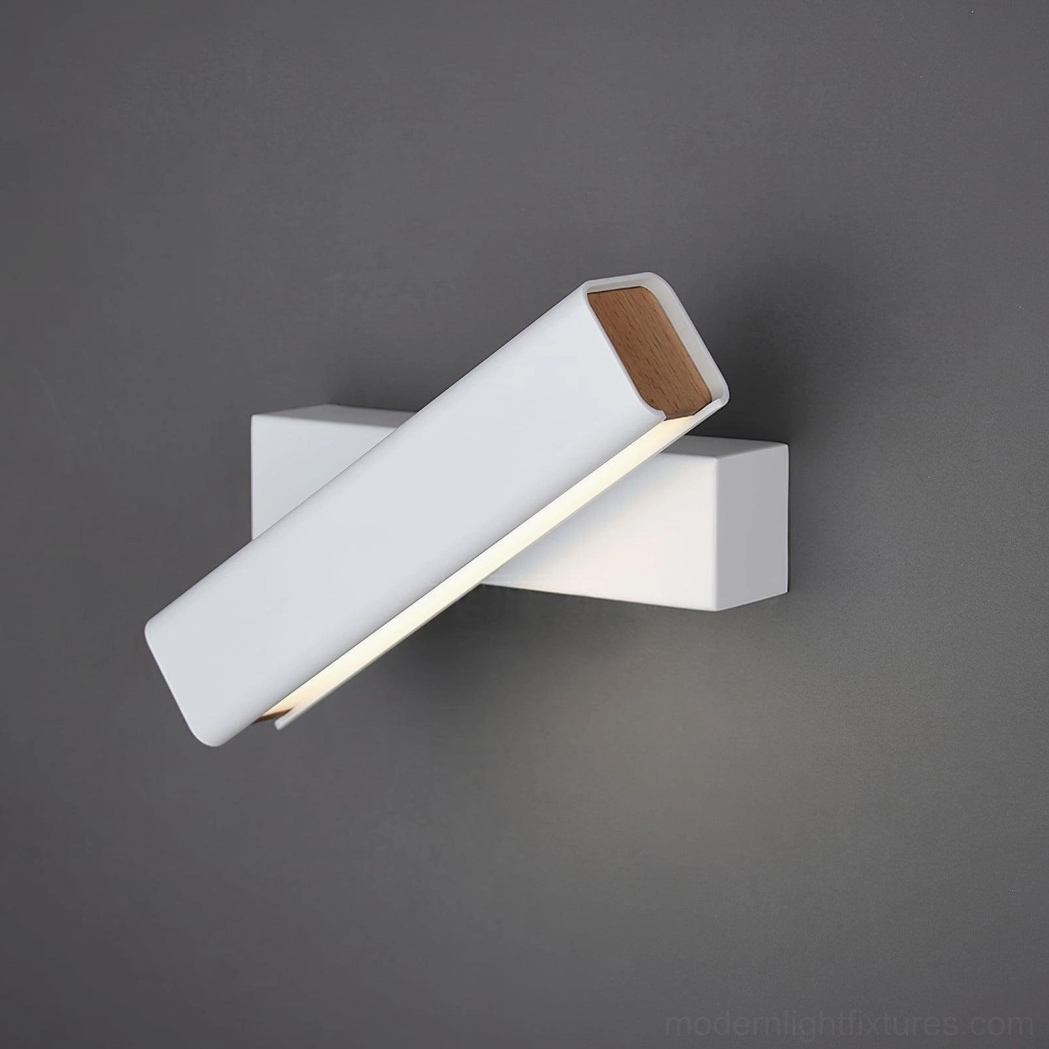 Nordic minimalist wall sconce in white matte finish, installed in contemporary bedroom space