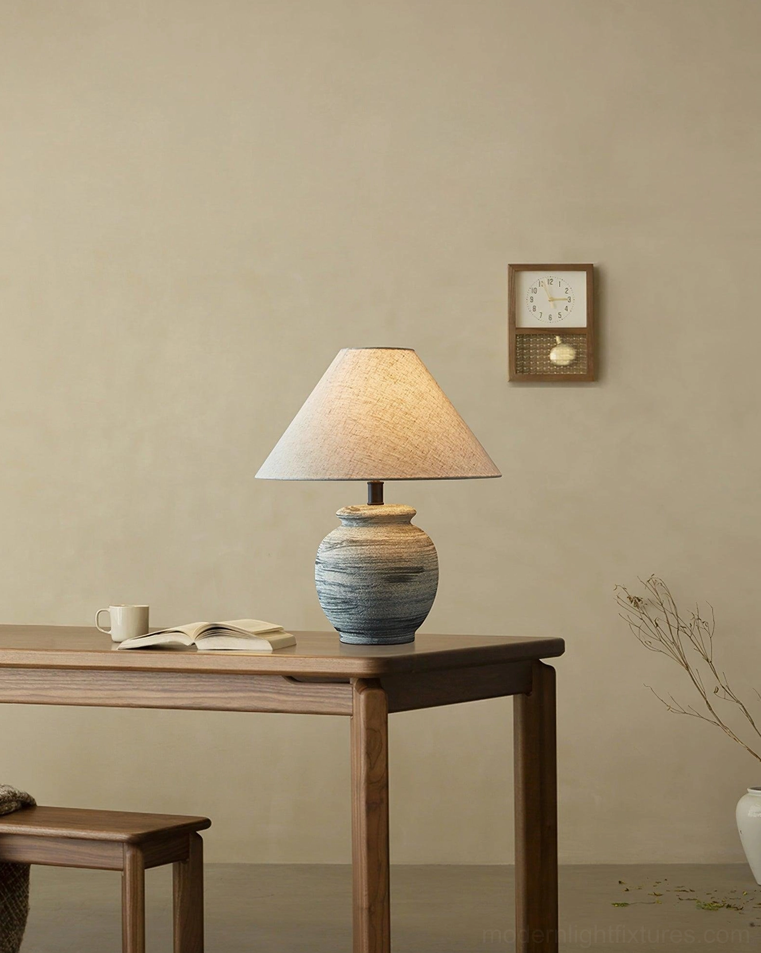 Norma table lamp on minimalist wooden desk with wall clock backdrop, modern home office styling