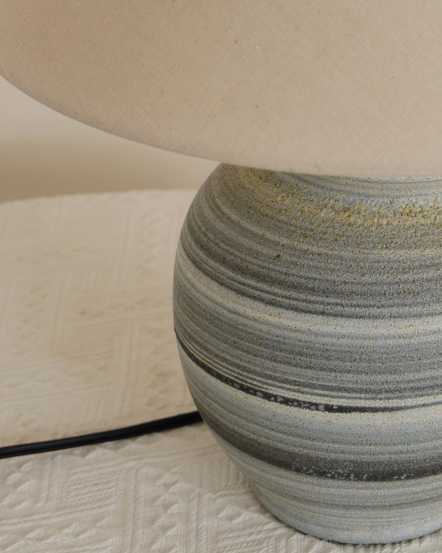 Norma table lamp providing task lighting on office desk in contemporary workspace with natural elements