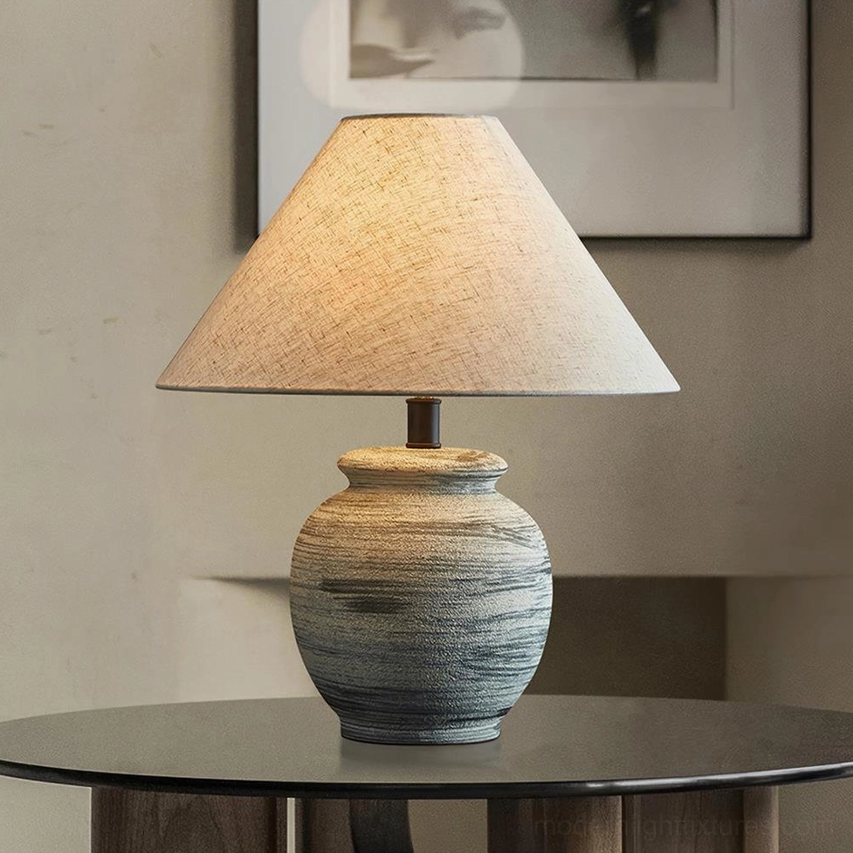 Norma table lamp displayed on dark round wooden table in minimalist interior setting, three-quarter view