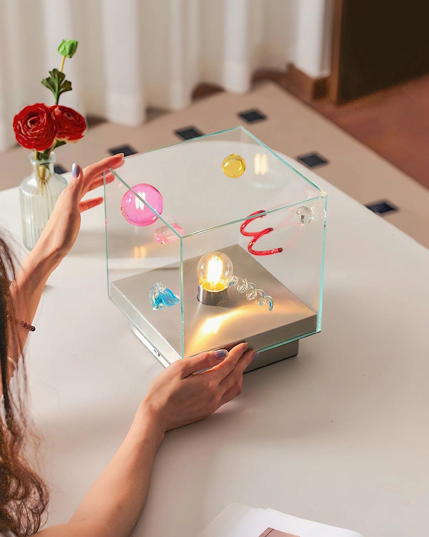 Nova Box Cube Table Lamp with person adjusting lamp showing warm ambient glow