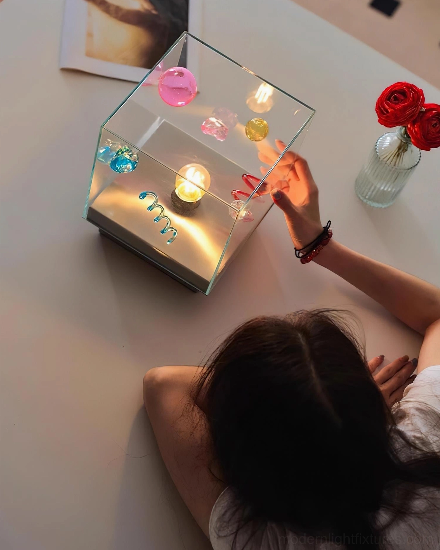 Nova Box Cube Table Lamp person interaction with glowing warm light and red rose decor