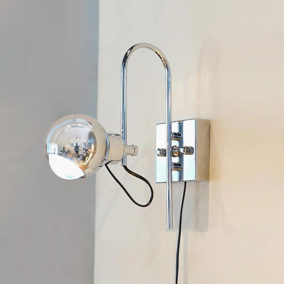 Nova Dot chrome wall sconce with unlit clear spherical shade mounted on square chrome wall bracket against gray corner