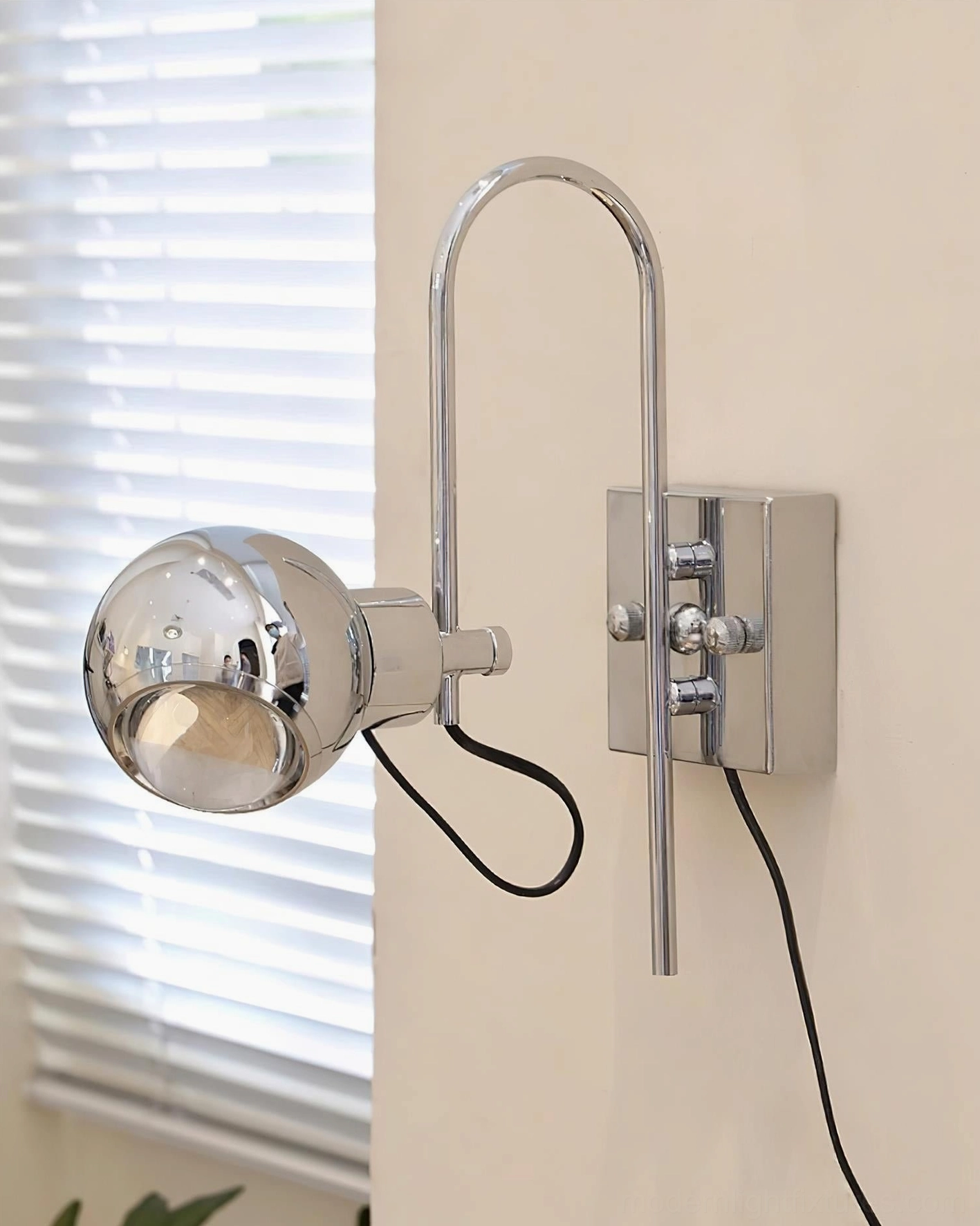 Nova Dot wall sconce with clear spherical shade and black power cord against white indoor wall with window blinds