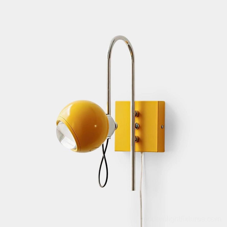 Nova Dot yellow mid-century modern wall sconce with adjustable chrome stem on white indoor wall, left front side view